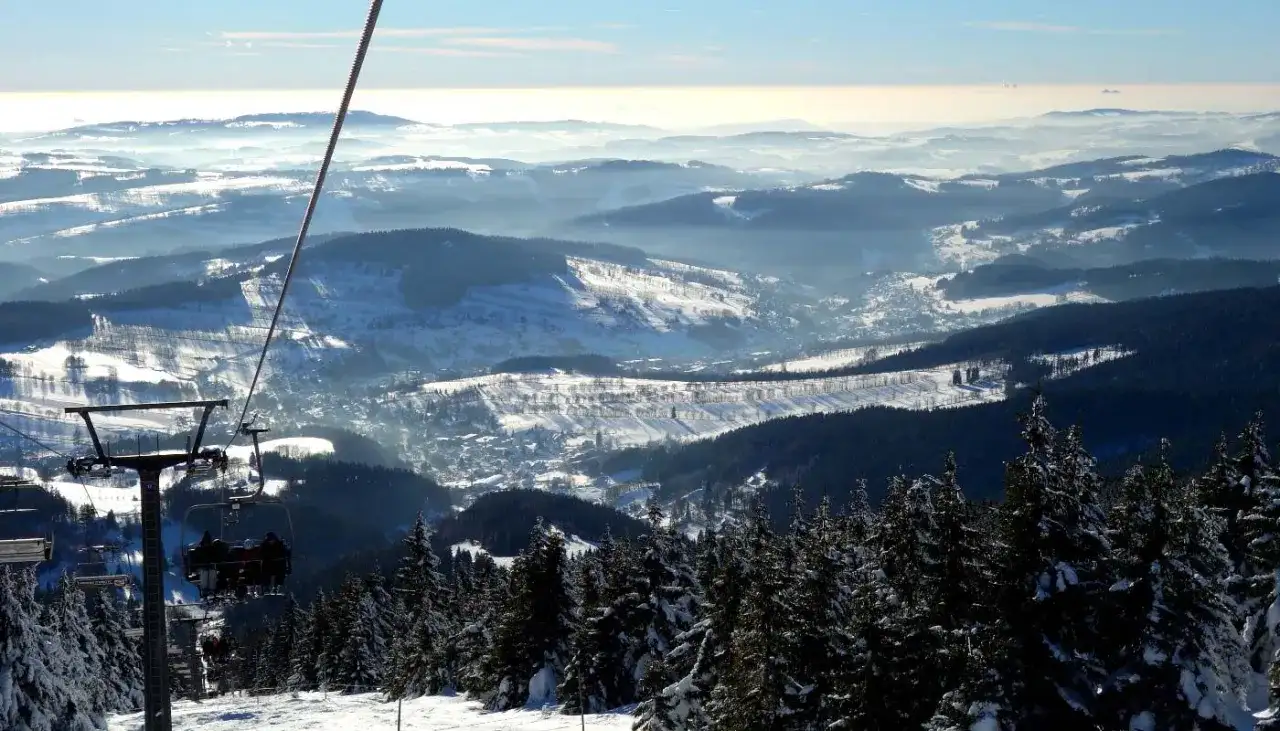 Blick vom Sessellift im Rokytnice Skigebiet auf verschneite Berge und Täler.